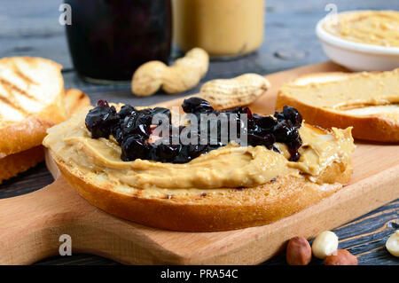 Croccante pane tostato con burro di arachidi e marmellata di frutti di bosco. Tradizionale colazione Americana. Foto Stock