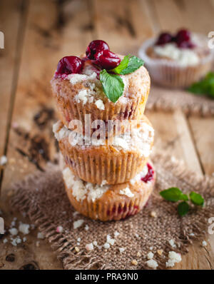 Close-up di ciliegia muffin con topping friabile su sfondo di legno Foto Stock