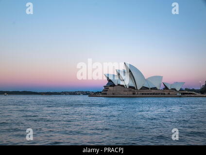 Vista di Sydney Opera House prese al tramonto durante il blu ora con il sole di setting colata di una bella tonalità bluastra intorno all'iconico punto di riferimento. Foto Stock