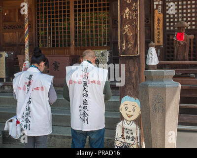 Pellegrini Henro pregando, Nankobo, tempio 55, Shikoku 88 tempio pellegrinaggio, Ehime Giappone Foto Stock