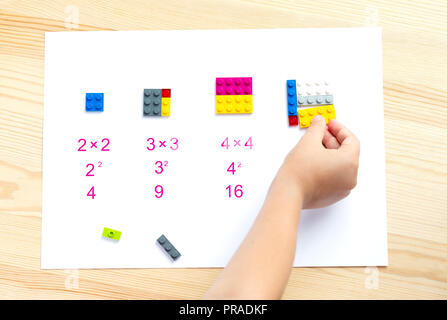 Il bambino mette i blocchi colorati nel posto giusto. Math giochi per bambini. Matematica, logica, formazione Foto Stock