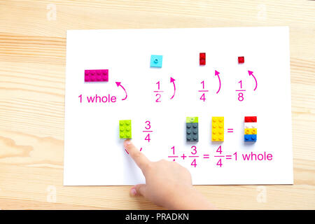 Il bambino mette i blocchi colorati nel posto giusto. Math giochi per bambini. Matematica, logica, formazione Foto Stock