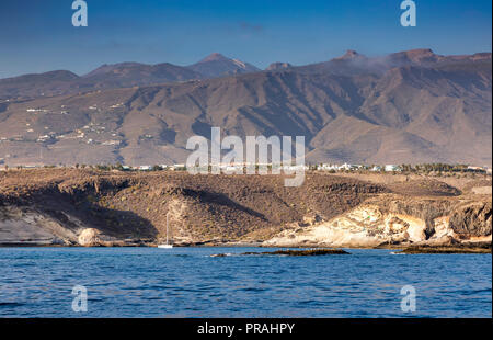 TENERIFE, Spagna - 21 agosto: (nota del redattore: un filtro polarizzante è stato utilizzato per questa immagine.) La Playa de los Morteros beach è visto a Costa Adeje il 21 agosto 2018 a Tenerife, Spagna. In alto al centro del paesaggio è il picco del vulcano Teide visibile. Foto Stock