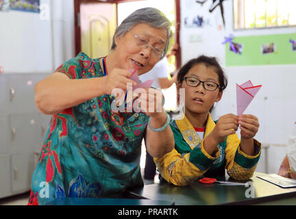 (181001) -- NANCHANG, 1 ottobre, 2018 -- Un residente (L) incarica uno studente di tibetani gruppo etnico sul taglio della carta di Nanchang, a est della capitale cinese della provincia di Jiangxi, Sett. 30, 2018. Una ventina di studenti del popolo tibetano gruppo etnico dal n. 17 Middle School ha celebrato la Cina della Giornata Nazionale con i residenti locali e gli studenti. Della Cina di Giornata Nazionale cade il 1 ottobre. (Xinhua/Hu Chenhuan) (Ly) Foto Stock