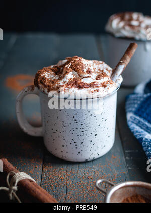 Cioccolata calda con panna montata e la stecca di cannella su sfondo scuro Foto Stock