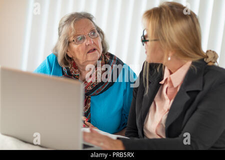 La donna aiuta adulti Senior Lady sul computer portatile. Foto Stock