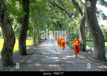 I monaci con elemosinare bocce sotto abiti dello zafferano uscire la mattina a ovest del Vietnam Foto Stock