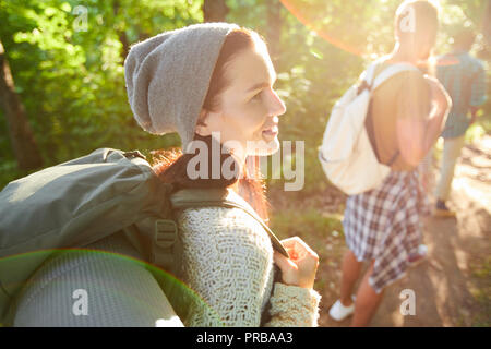 Giovani piuttosto camper con zaino a parlare con uno dei tuoi amici sul loro modo di camp Foto Stock