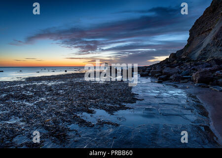 Sunrise over Saltwick Bay appena al di fuori di Whitby nel Nord Yorkshire coast Foto Stock