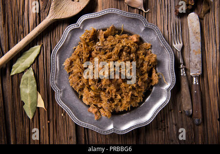 Cavolo nero stufato con carne, funghi e prugne secche - piatto tradizionale polacca Foto Stock