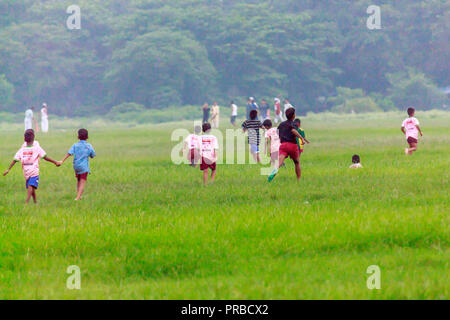 I bambini in esecuzione nel Parco di primavera campo in abiti casual, bambini, ragazzi e ragazze, neri e caucasici. Holiday event travel vacanze estive a scuola Foto Stock
