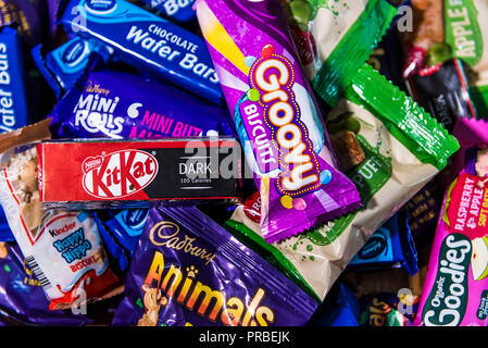 Un assortimento di caramelle cioccolata in barre colorate di involucri. Foto Stock