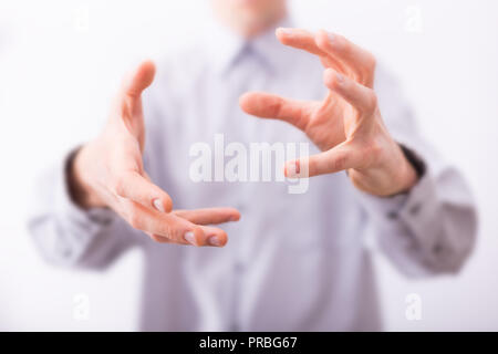 Maschio sono mani che mostra gesto prendersi cura di qualcosa. Foto Stock