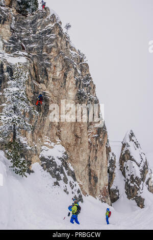 Fuori pista gli sciatori sono praticare arrampicate su roccia. Foto Stock