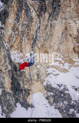 Fuori pista gli sciatori sono praticare arrampicate su roccia. Foto Stock