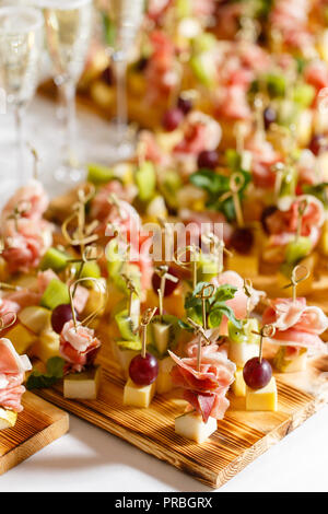 Spuntini leggeri in una piastra su un tavolo da buffet. Mini assortiti tartine, delizie e snack, ristorante cibo a caso. Un ricevimento di gala. Decorate una deliziosa tavola per un partito goodies. Foto Stock