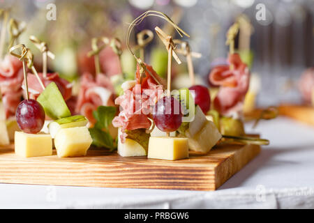 Spuntini leggeri in una piastra su un tavolo da buffet. Mini assortiti tartine, delizie e snack, ristorante cibo a caso. Un ricevimento di gala. Decorate una deliziosa tavola per un partito goodies. Foto Stock