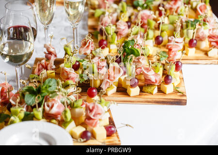 Spuntini leggeri in una piastra su un tavolo da buffet. Mini assortiti tartine, delizie e snack, ristorante cibo a caso. Un ricevimento di gala. Decorate una deliziosa tavola per un partito goodies. Foto Stock