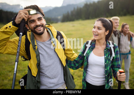 Backpackers felice coppia giovane escursionismo con bastoni Foto Stock