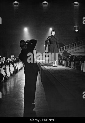 Anni Cinquanta la moda. Un modello di moda è a piedi sulla passerella. La silhouette di un photograher nella parte frontale mostra lui alzando la fotocamera per scattare una foto del modello. La Svezia 1952. Ref A42-9 Foto Stock