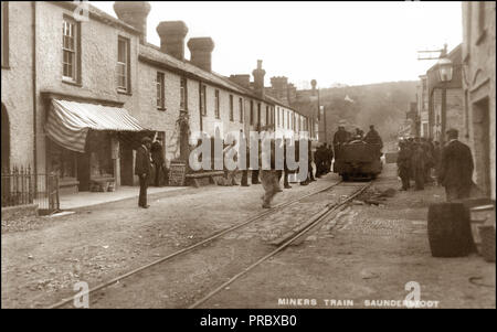 I minatori in treno in 1800's Saundersfoot Pembrokeshire Wales. Il Saundersfoot stazione e il porto società è stata costituita nel 1828 per costruire un porto a Saundersfoot e una linea tramviaria per connetterlo a bacini intorno Begelly Stepaside e. La tramvia originariamente utilizzati cavalli per tirare fino a tre carri con carico lungo i binari. La prima linea è stato costruito in due fasi per collegare bacini vicino Stepaside e la ferriera a Saundersfoot in esecuzione lungo attraverso brevi gallerie e terminante in corrispondenza del centro del villaggio vicino al porto. La seconda linea corse dal porto di Thomas Cappella colliery, Begelly. Foto Stock