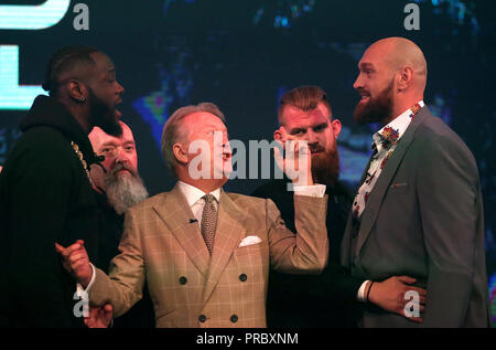 Deontay Wilder (sinistra) e Tyson Fury (destra) reagiscono come promotore Frank Warren (centro) li tiene separati nel corso di una conferenza stampa a BT Sport Studio, Londra. Foto Stock