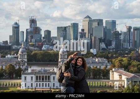 Londra Panorama dal parco di Greenwich, in Inghilterra, Regno Unito. 22 settembre 2018 tenendo selfie fotografie con Canary Wharf come sfondo. Xx e xxi cntury può Foto Stock