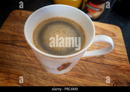 La tazza di caffè nero da sopra visto su un tagliere Foto Stock