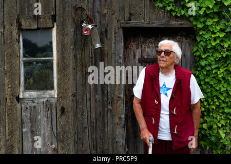 Donna anziana affetti da degenerazione maculare nei suoi occhi rendendo la sua tenda parzialmente Foto Stock