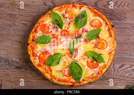 Pizza con prosciutto e patate servita il basilico Foto Stock