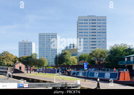 Elevato aumento di blocchi di ex consiglio appartamenti vicino al canale nel centro di Birmingham con la Biblioteca di Birmingham in background Foto Stock