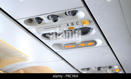 Primo piano immagine di pulsanti e spie sul soffitto sopra il sedile pasenger in aereo Foto Stock