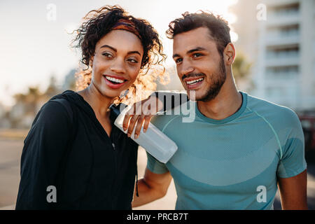 Matura in usura fitness relax all'aperto al mattino. Coppia sorridente in piedi insieme prendendo una pausa dopo il lavoro fuori. Foto Stock