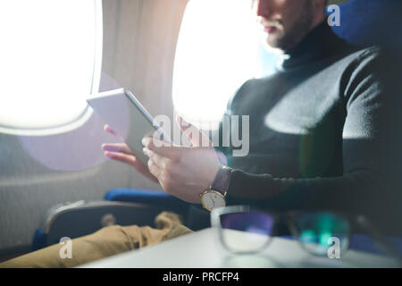 Uomo che utilizza Tablet in aereo Foto Stock