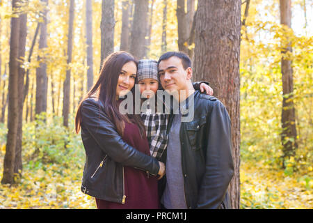 I bambini, la natura e il concetto di famiglia - Ritratto di famiglia felice su autunno sfondo parco Foto Stock