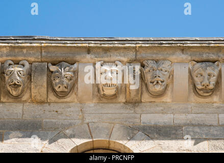 Scolpite le teste di pietra sopra la facciata a sud di La Basilique Sainte-Marie-Madeleine (Vézelay abbazia), Yonne, Borgogna, in Francia, in Europa Foto Stock