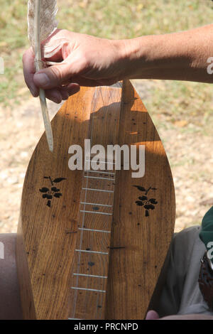 Persona che gioca Appalachian Dulcimer utilizzando una piuma Foto Stock