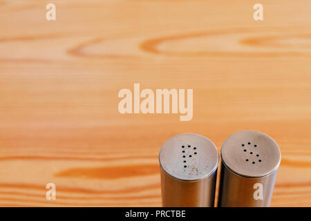 Sale shaker e pepaiola su un tavolo di legno, un sacco di spazio per il testo, copyspace Foto Stock