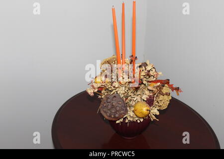 Close up di autunno progettazione di candele, fiori e frutti sul tavolo di legno Foto Stock