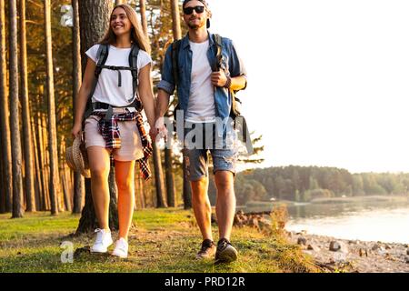 Percorso difficile. Bella coppia Giovane escursionismo insieme nei boschi mentre godendo il loro viaggio. Foto Stock