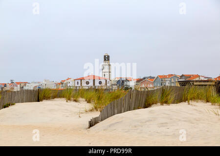 Spiaggia di Costa Nova con recinto di sabbia e la vista della città al di là. Famosa destinazione di vacanza situato in Aveiro, Portogallo Foto Stock