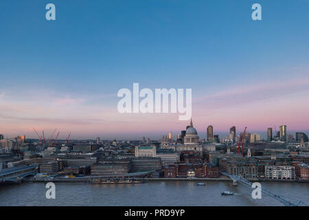 Lo skyline di Londra con vista sul fiume Tamigi, la Cattedrale di St Paul e il Barbican edifici in background con i lavori di costruzione di gru nel crepuscolo tramonto Foto Stock