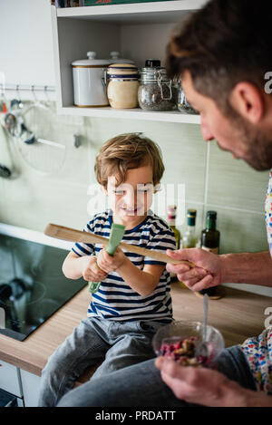 Little Boy sta avendo lotta con papà è in cucina Foto Stock