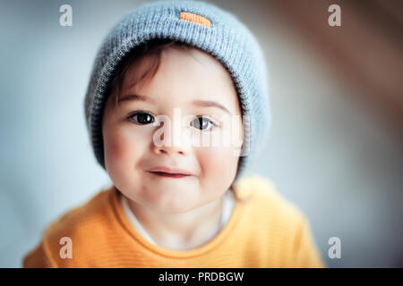 Ritratto di un simpatico sorridenti little baby indossando eleganti vestiti caldi, kids fashion, look alla moda nella stagione autunnale per i ragazzi Foto Stock