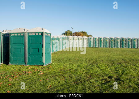 Una linea di cabine temporanee per toilette. Molti servizi igienici portatili in un campo, Nottingham, Inghilterra, Regno Unito Foto Stock
