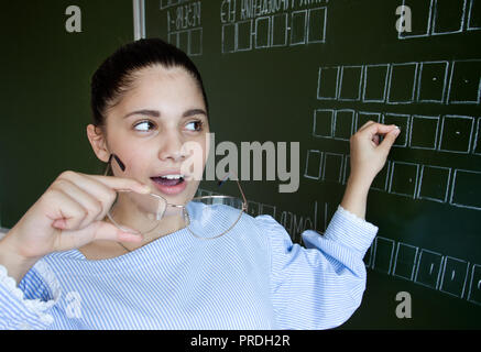 Sorpresa studente che scrive sulla lavagna con Chalk Foto Stock