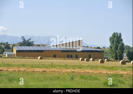 Il tetto a energia solare di una grande superficie su un edificio rustico di un piccolo villaggio dei Pirenei Foto Stock