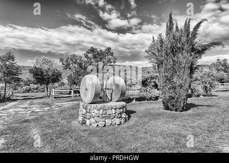 Antico frantoio con due macine in campagna Foto Stock