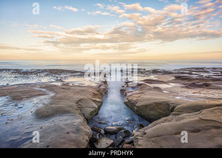 La Jolla, California, Stati Uniti d'America. Costa rocciosa con un nuvoloso sunrise. Questa zona è chiamata Hospital il reef. Foto Stock