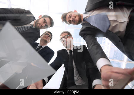 Vista dal basso.business partner per discutere i dettagli del contratto Foto Stock